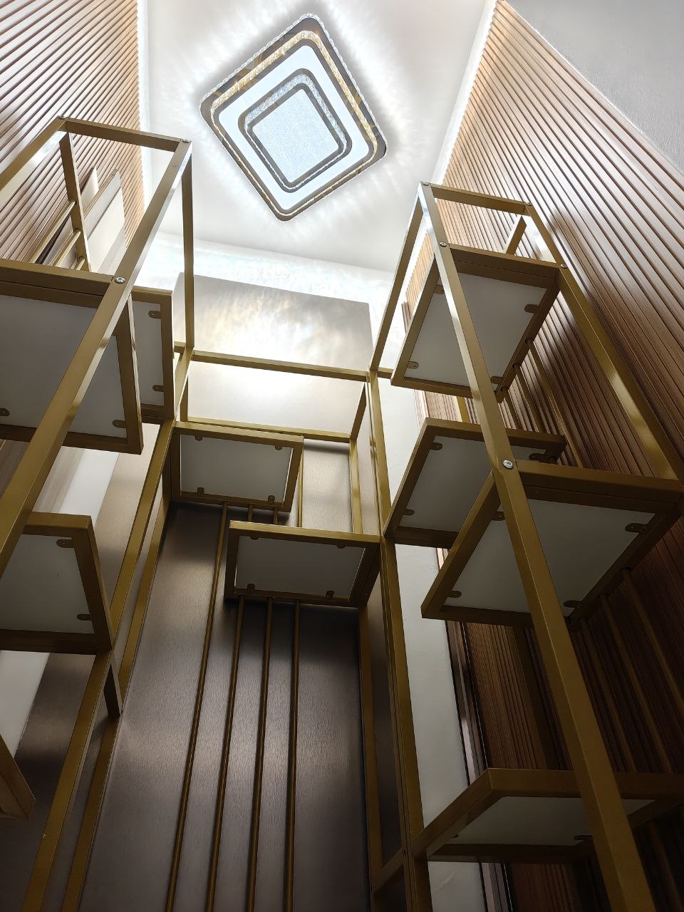 Gold-framed storage with fluted timber and sculptural ceiling light